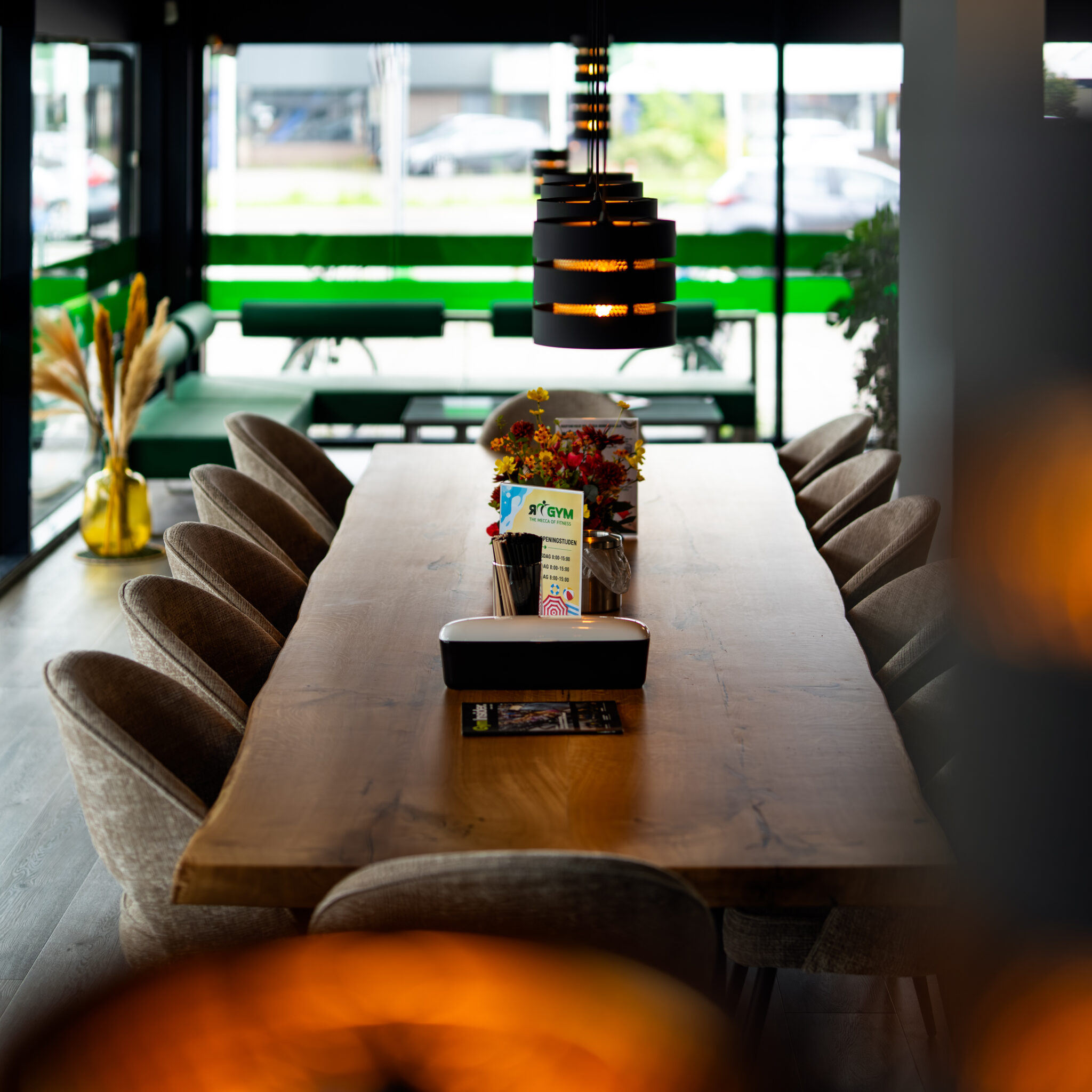 Lange tafel en zitruimte binnen RGym